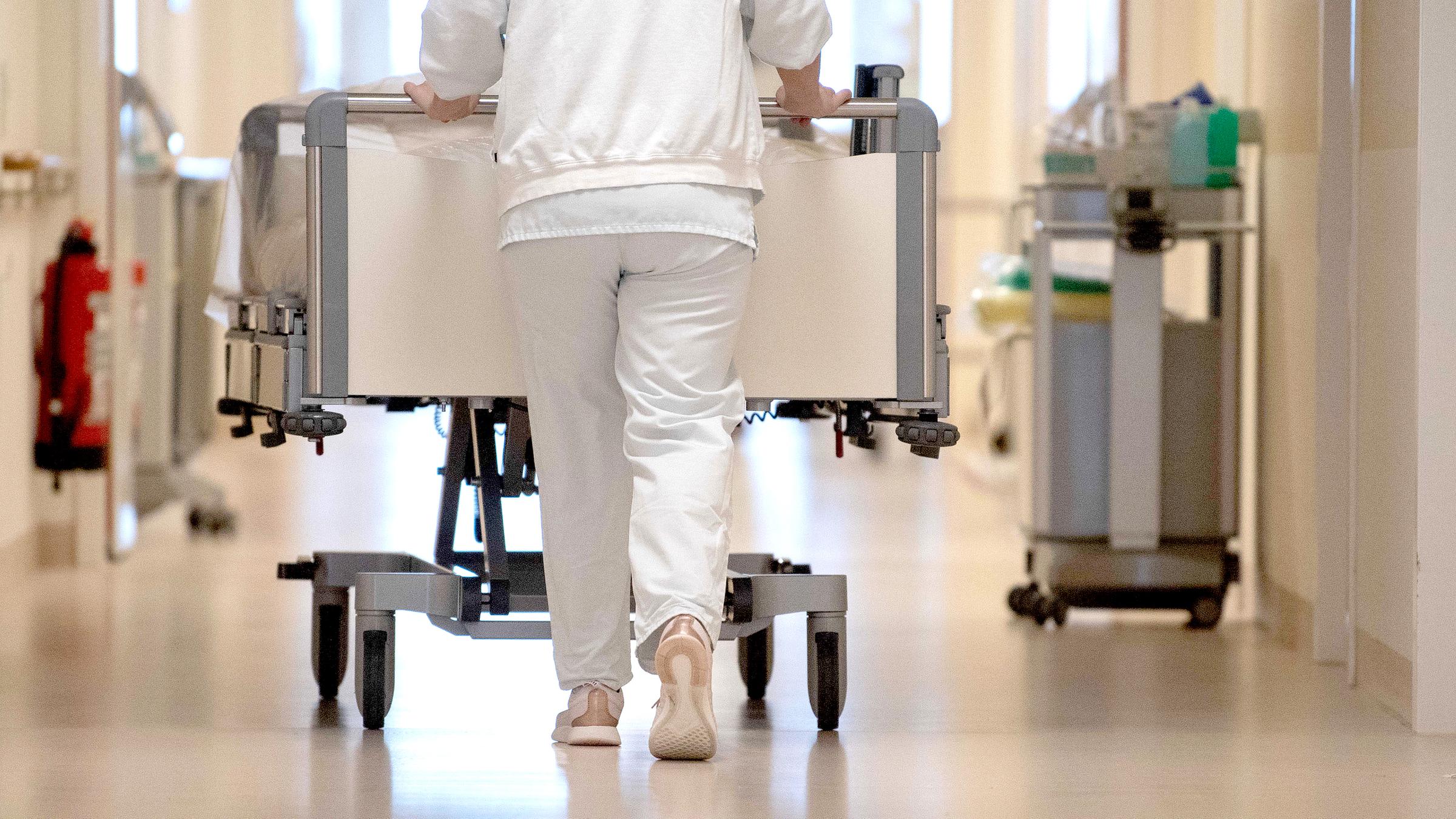 Eine Krankenpflegerin schiebt ein Krankenbett durch einen Flur., aufdgenommen am 20.01.2020