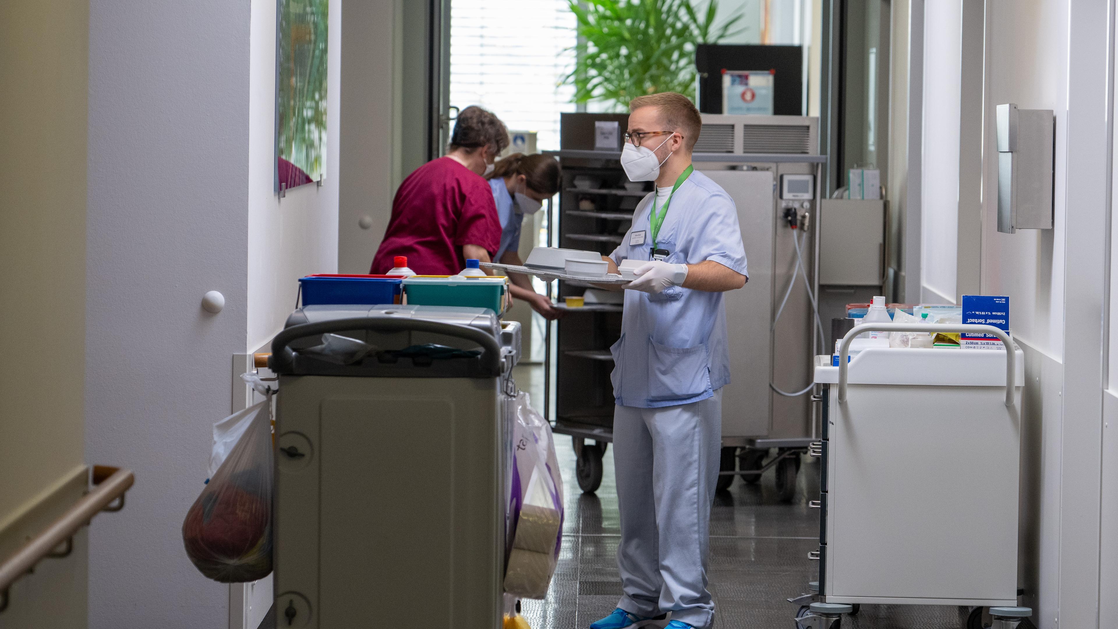 Baden-Württemberg, Blaubeuren: Im Krankenhaus verteilt ein Pfleger auf der Station Esssen.