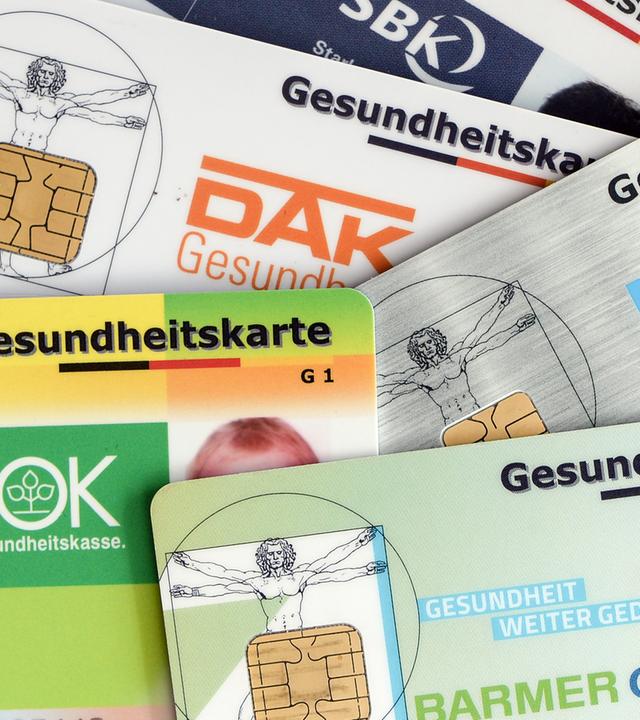 Berlin: Gesundheitskarten verschiedener Krankenkassen liegen auf einem Tisch. Archivbild