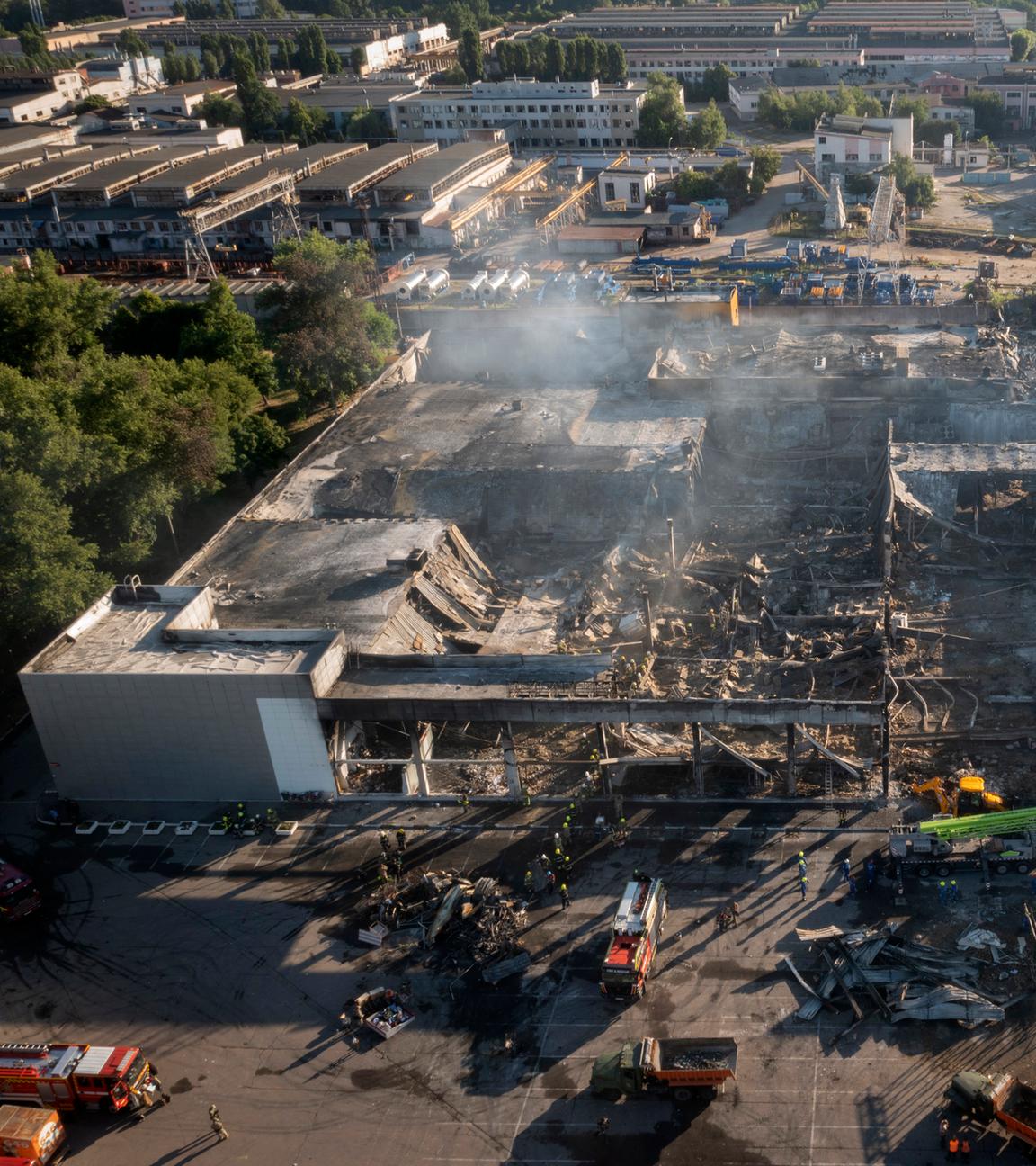 Das Einkaufszentrum in Krementschuk ist nach Angriffen zerstört. Feuerwehrleute löschen und beseitigen die Trümmer.