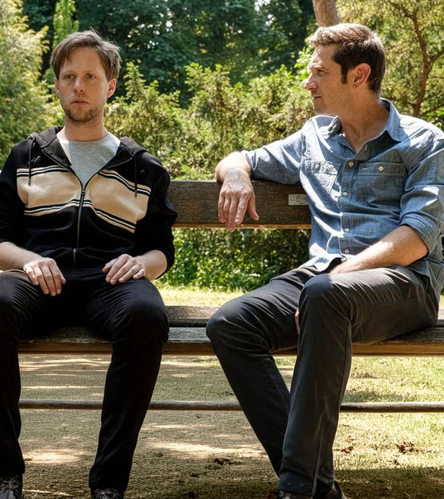 "SOKO Wien - Kreuzmordrätsel": Bezirksinspektor Klaus Lechner (Andreas Kiendl) sitzt zusammen mit Louis Mahrer (Markus Freistätter) auf einer Parkbank. Louis schaut sehr starr geradeaus und hat seine Hände auf den Oberschenkeln abgelegt. Bezirksinspektor Lechner hat seinen rechten Arm auf der Rücklehne abgelegt und hat sich Louis zugewandt.