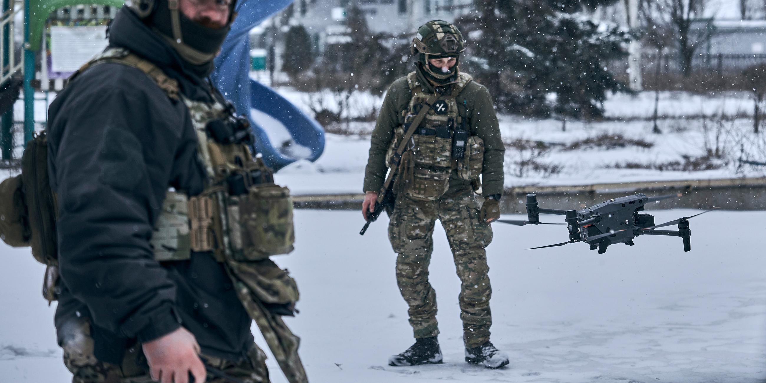 Ukrainische Soldaten stehen neben einer fliegenden Drohne, aufgenommen am 12.02.2023 in Bachmut (Ukraine)
