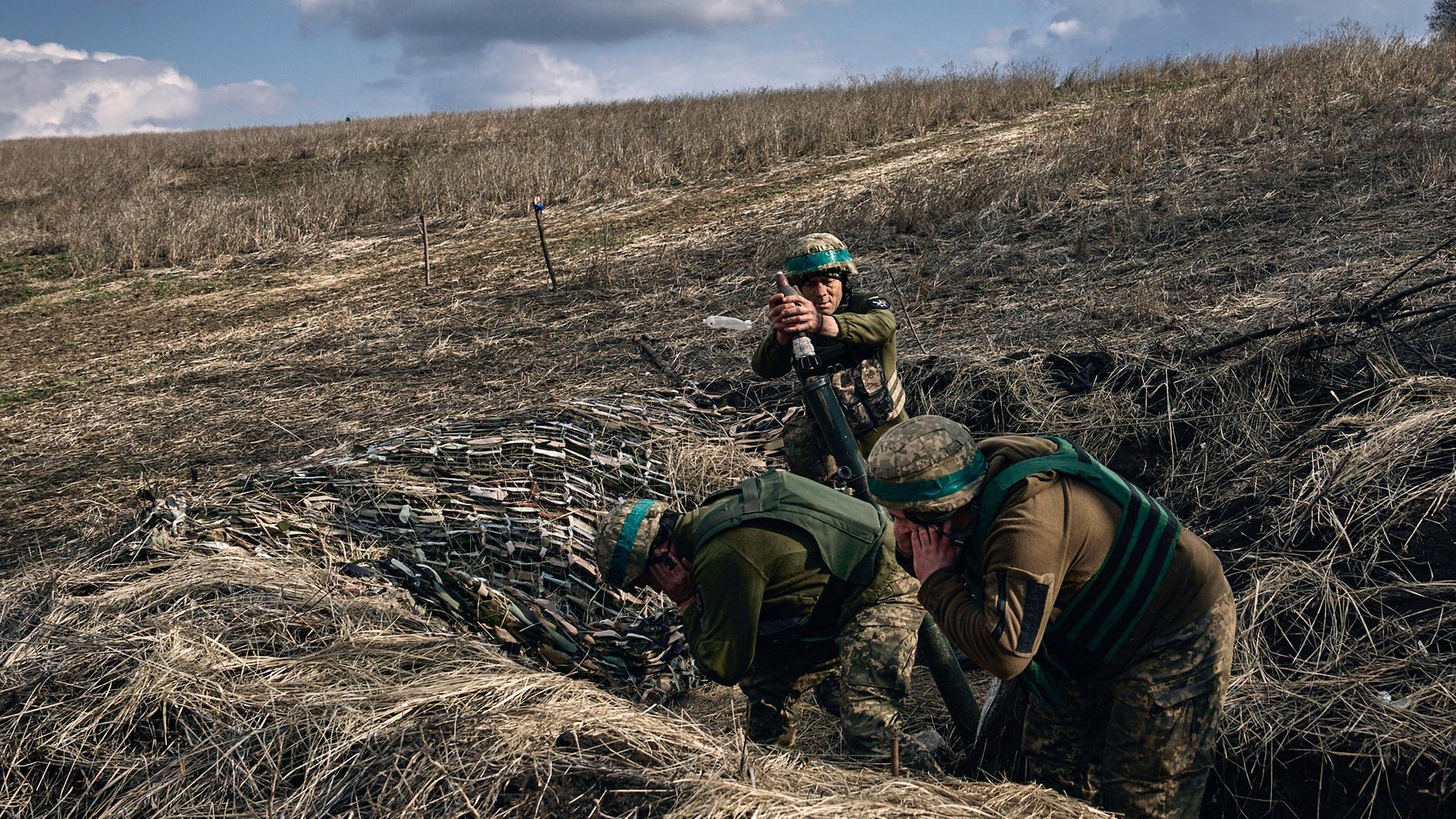 Ukrainische Soldaten feuern einen Mörser auf russische Stellungen an der Frontlinie in der Nähe von Bachmut in der Region Donezk, aufgenommen am 27.03.2023