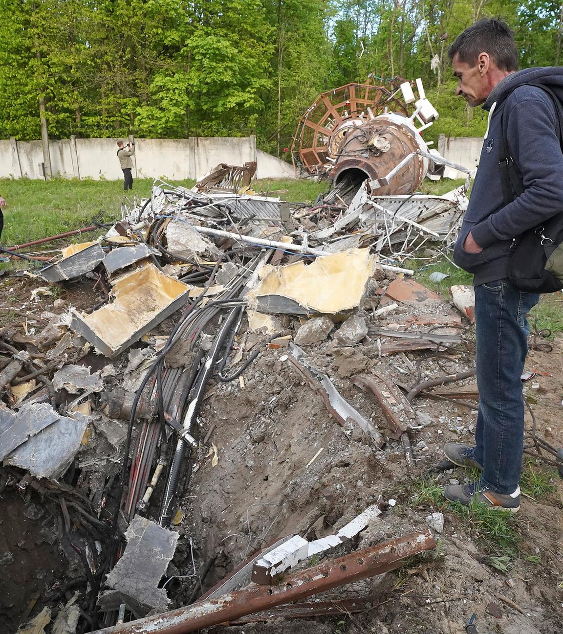 Menschen betrachten Fragmente des Fernsehturms, der nach dem Einschlag einer russischen Rakete in Charkiw, Ukraine, am 22.04.2024, in zwei Hälften zerbrochen wurde