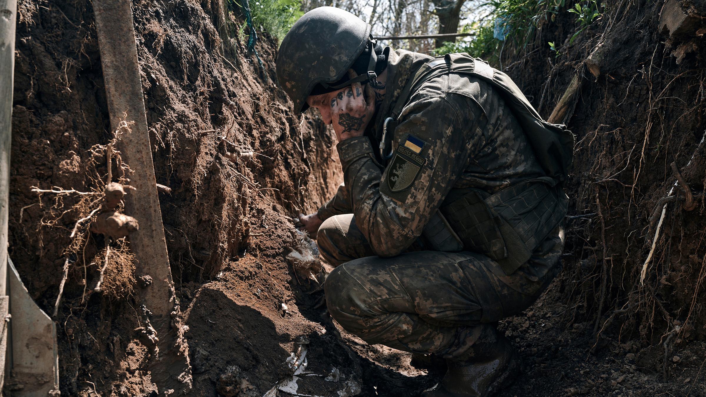 Ein ukrainischer Soldat sitzt in einem Graben an der Frontlinie, aufgenommen am 24.04.2023