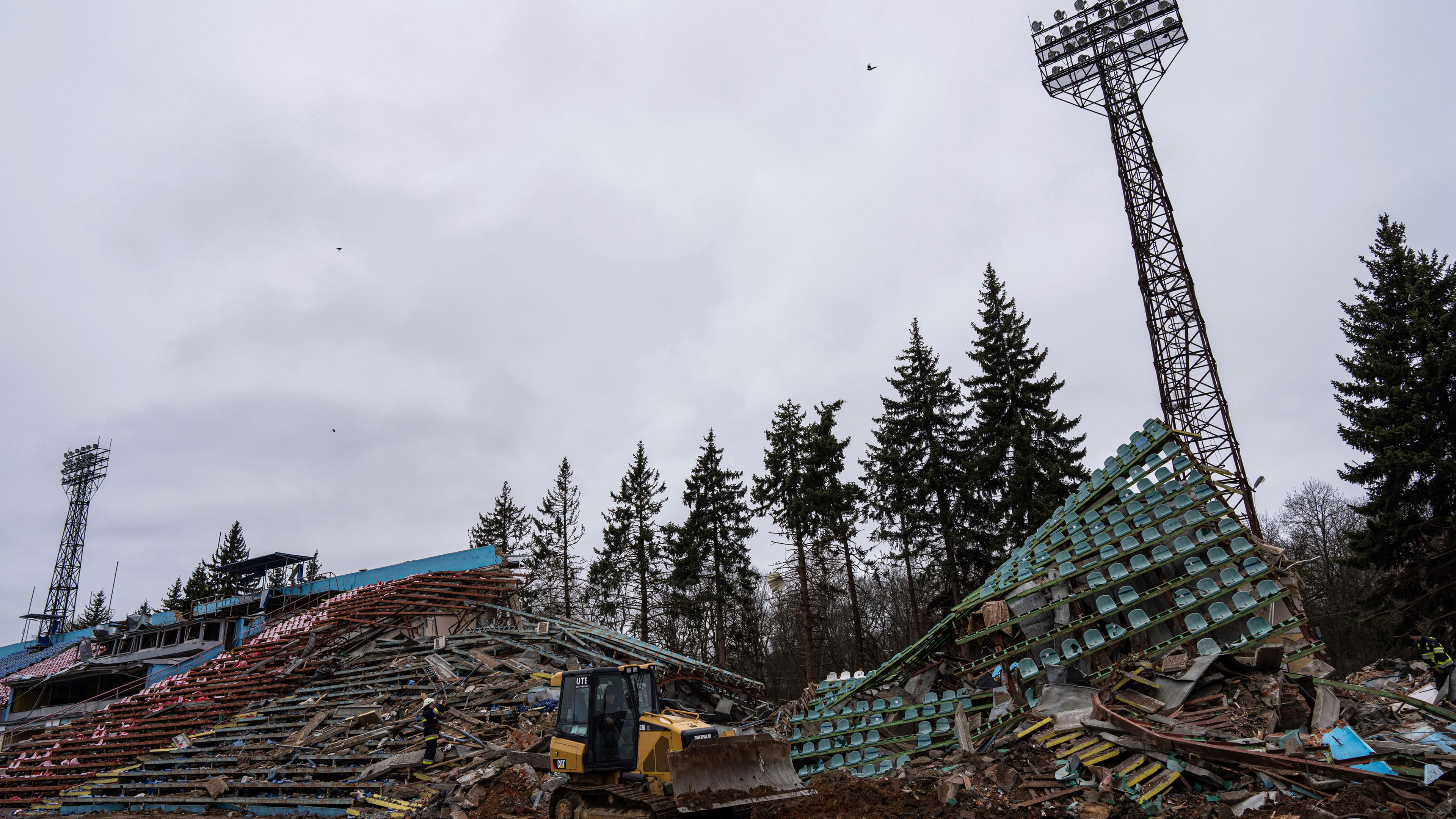 13.04.2022, Ukraine, Tschernihiw: Ein Bulldozer arbeitet an einem Stadion, das durch den Beschuss russischer Streitkräfte beschädigt wurde.