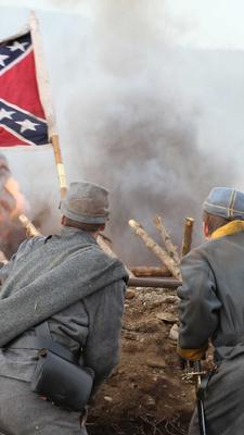 "Krieg um Amerika: Nashville - Kampf um den Süden": Rebellen haben sich hinter einem Erdwall verschanzt, in dem eine Flagge der Konföderierten steckt. Im Mittelgrund Feuer.