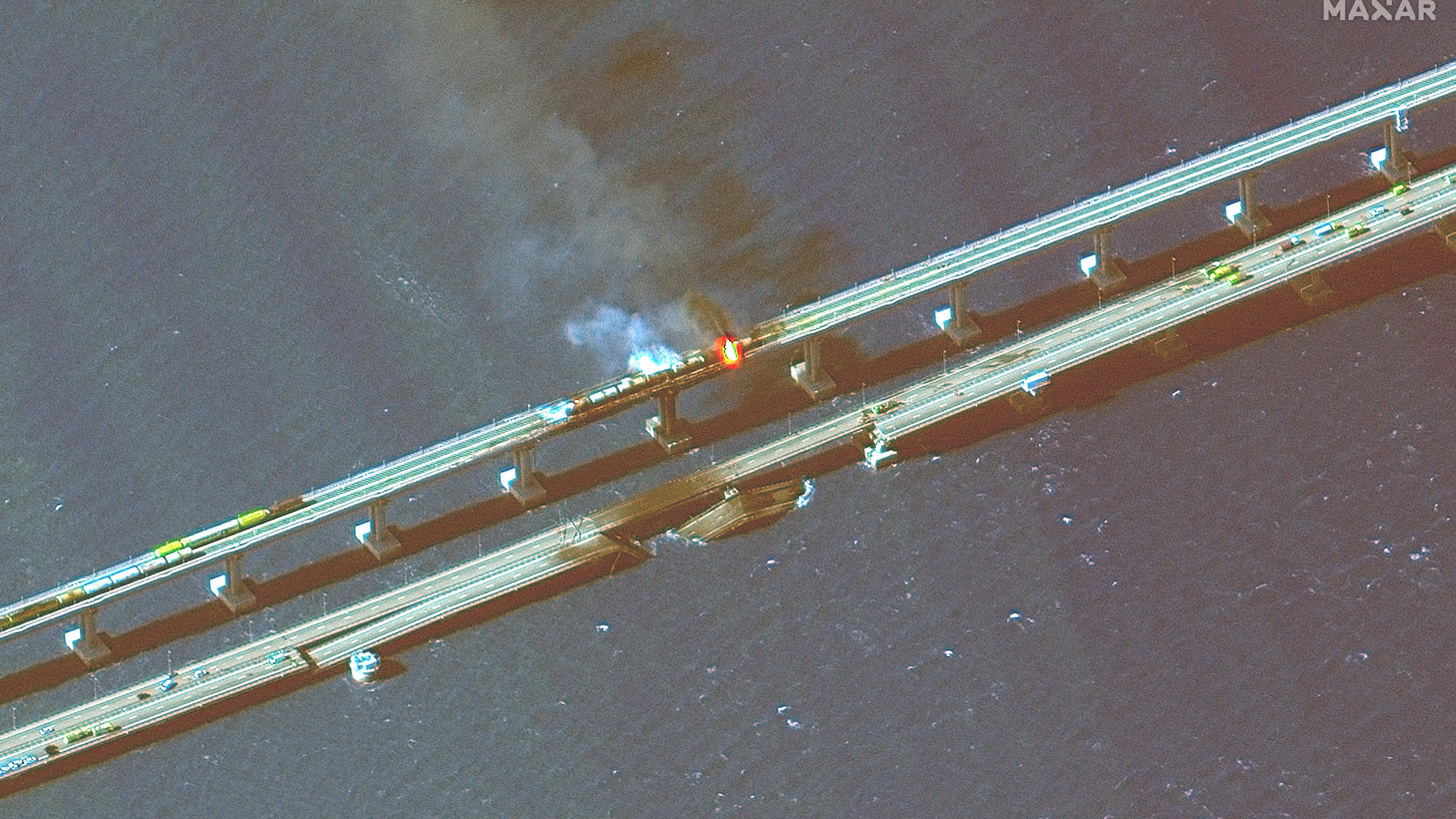 Dieses von Maxar Technologies bereitgestellte Satellitenbild zeigt brennende Eisenbahnwaggons und Schäden an der Krim-Brücke, die das russische Festland und die Halbinsel Krim über die Straße von Kertsch verbindet.