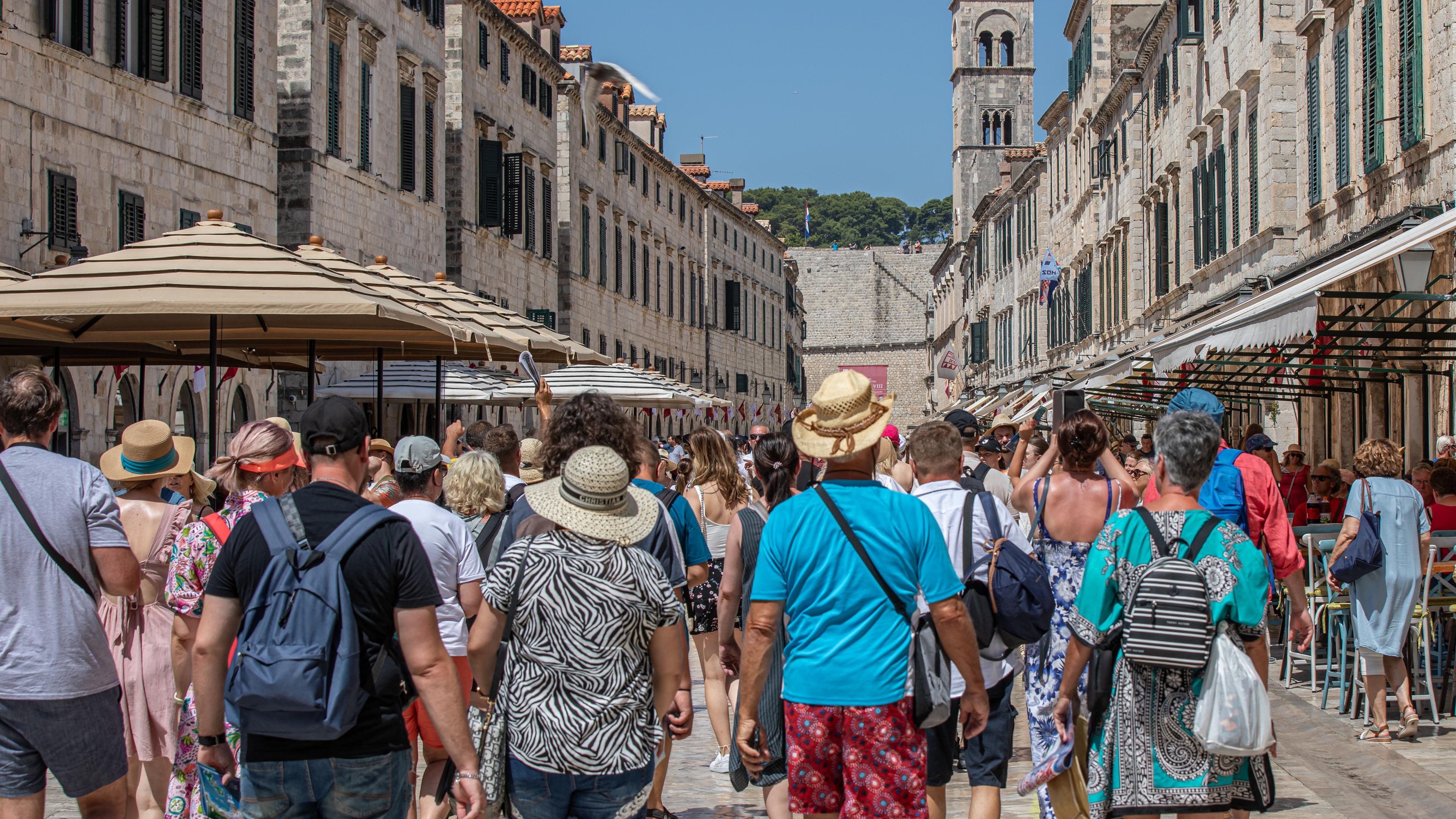 Kroatien, Dubrovnik: Touristen gehen an dem heißen Tag durch eine Geschäftsstraße von Dubrovnik.