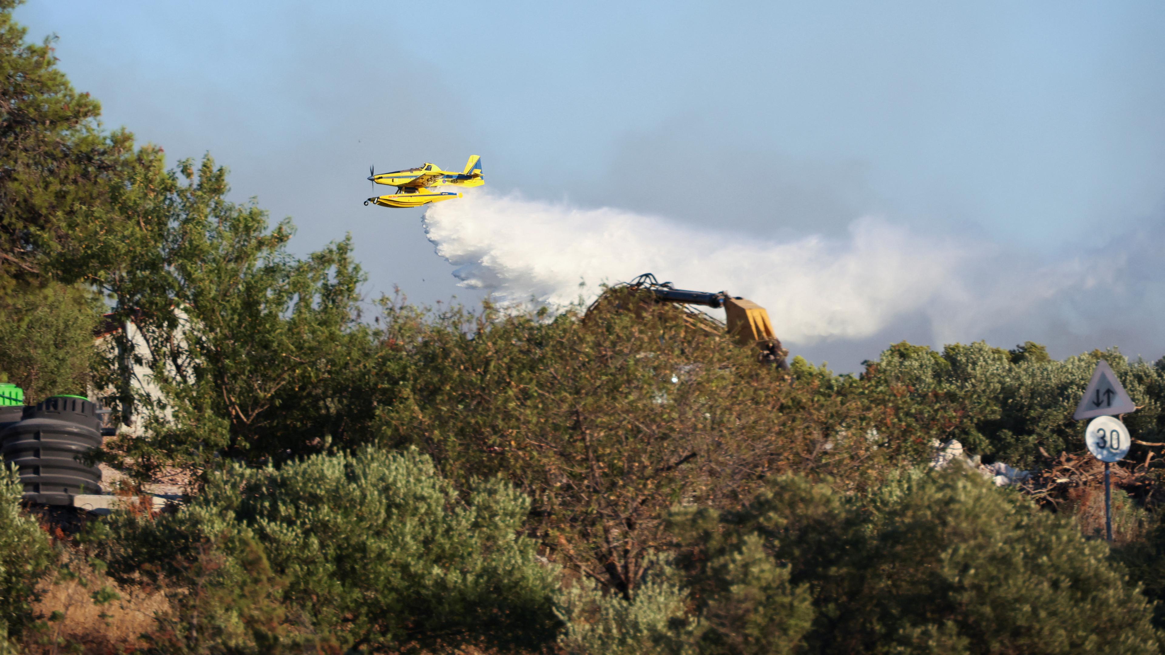 Ein Löschflugzeug wirft Wasser auf ein Feuer auf der Insel Ciovo, Kroatien, 27. Juli 2023.