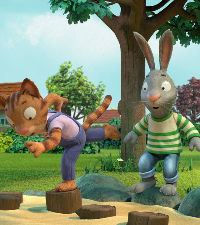 Draußen im Grünen: Das Kaninchen Pip steht mit erschrockenem Blick und weit geöffneten Augen auf einem großen Stein. Vor ihm im Sandkasten befindet sich das Katzenmädchen Frankie. Sie steht mit ihrem linken Bein auf einem Holzblock, das rechte Bein ist gerade nach hinten geschwungen, ebenso ihr rechter Arm. Ihr linker Arm zeigt nach vorne. Ihr Blick ist erschrocken und konzentriert. Im Sandkasten befinden sich weitere Holzblöcke. Im Hintergrund sind Häuser, Bäume Sträucher und Grünfläche zu sehen.