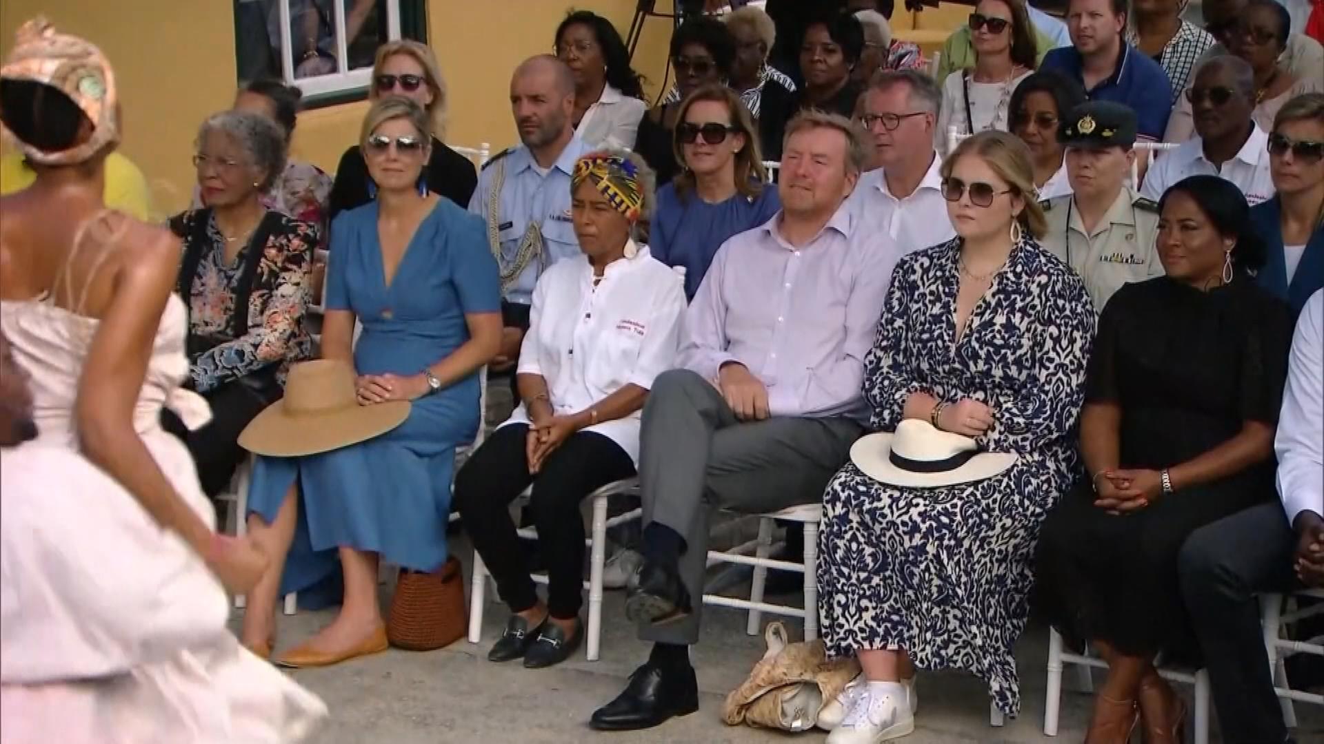 Niederländische Königsfamilie in der Karibik, sitzt bei einer Veranstaltung umgeben von anderen Menschen 