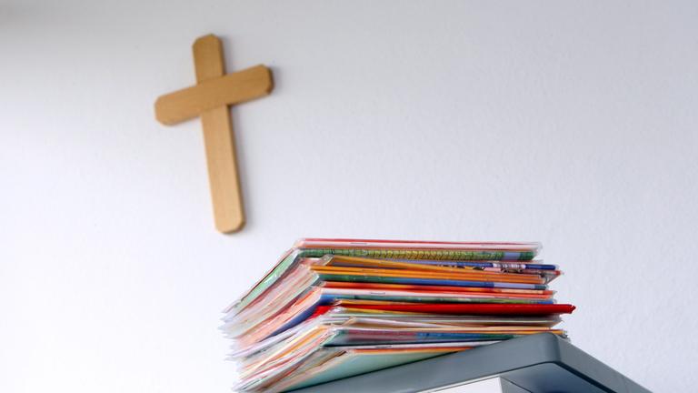 Ein Kruzifix hängt am 27.04.2010 in einem Klassenzimmer einer Grundschule in Kaufbeuren, Schwaben, hinter dem Lehrerpult mit Schulheften. 