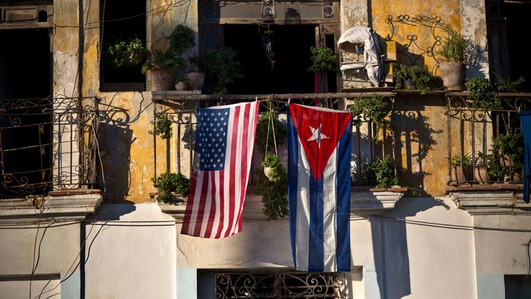Eine kubanische und eine US-amerikanische Flagge hängen nebeneinander an einem Balkon.