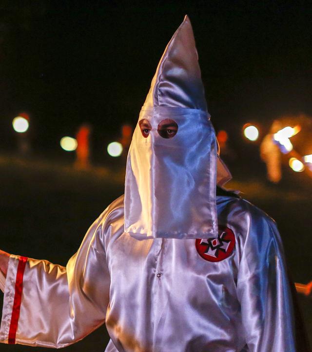 Mitglied des Ku Klux Klan mit brennender Fackel