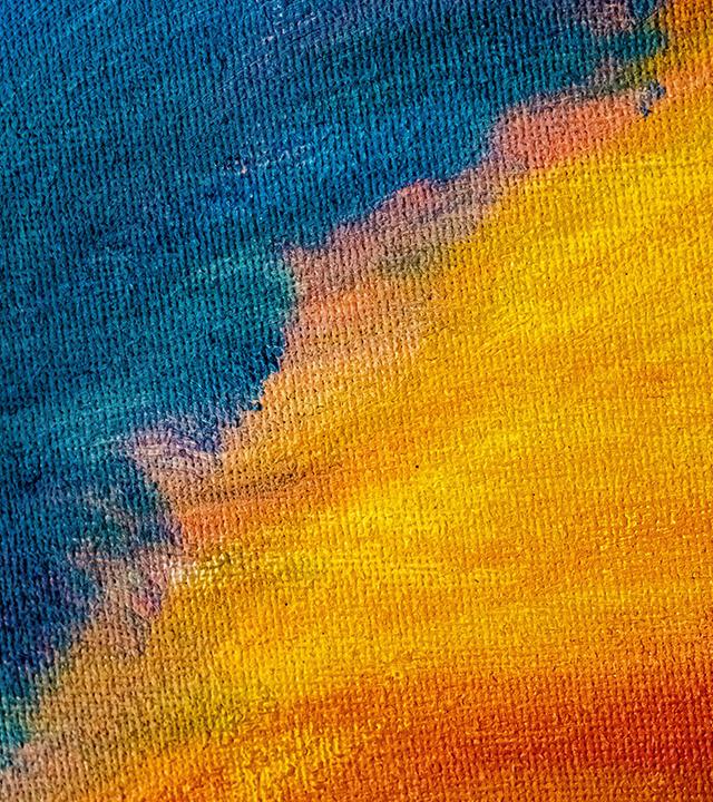 Abstraktes Bild: Körnige Farbflächen verlaufen von kühlem Blau zu warmen Gelb- und Rottönen und bilden eine diffuse, wolkenähnliche Struktur. Das Bild erzeugt den Eindruck eines abstrakten Himmels.