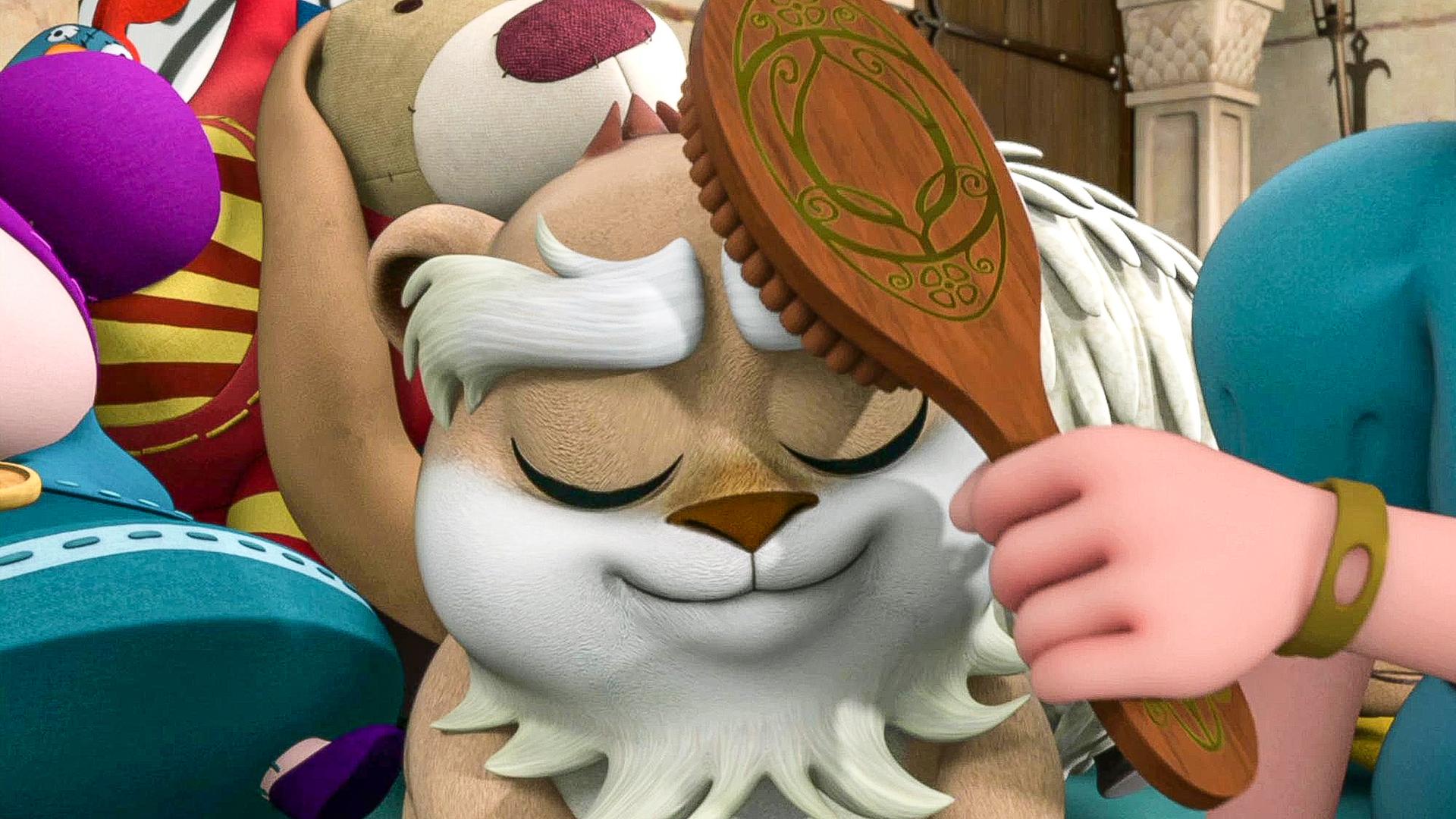 Der Hamster wird mit einer Bürste gebürstet. Er scheint es zu genießen. Im Hintergrund sind viele Kuscheltiere zu sehen.