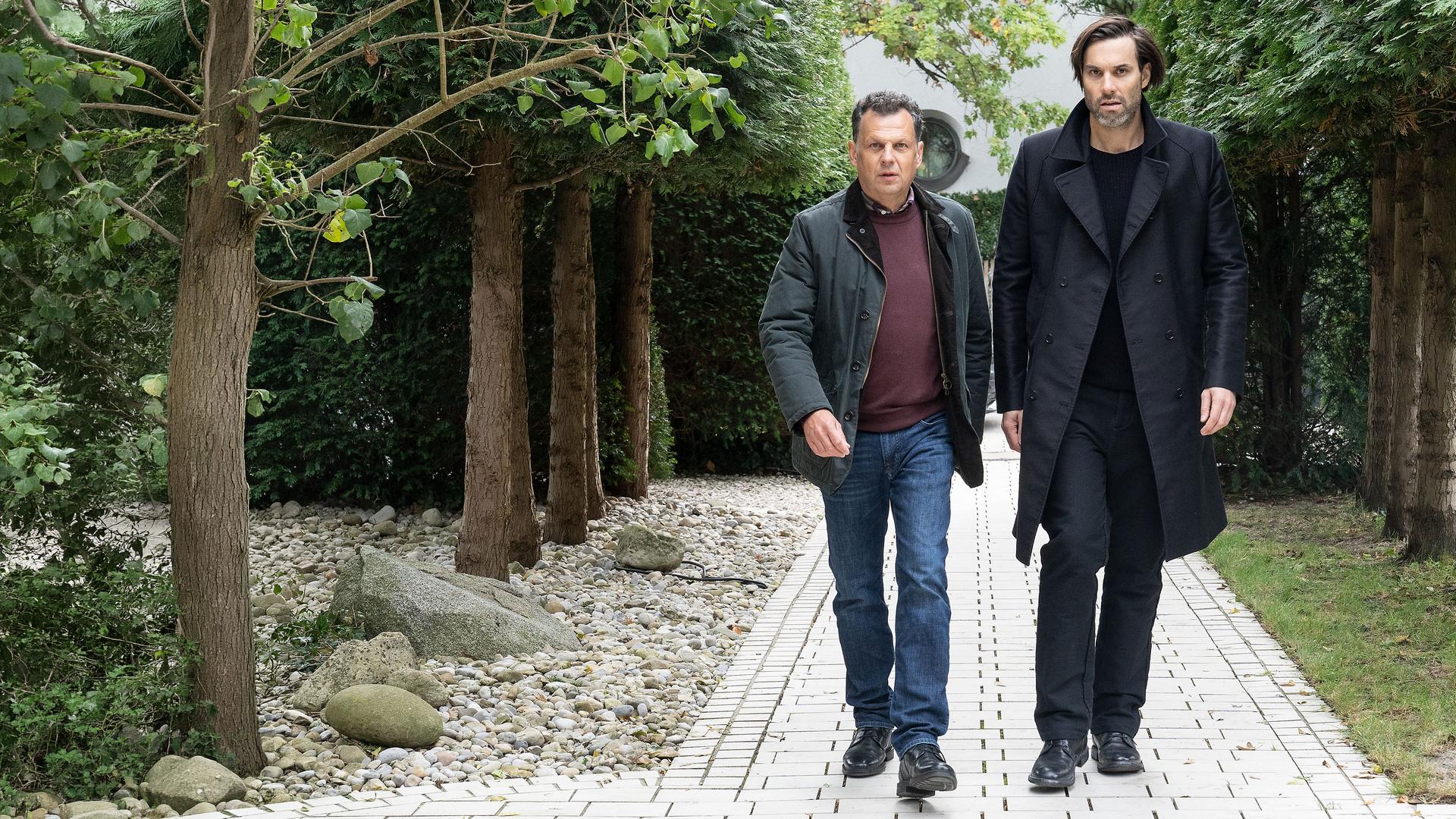 "Laim und die Toten ohne Hosen": Anton Simhandl (Gerhard Wittmann) und Lukas Laim (Max Simonischek) laufen nebeneinander einen Weg entlang.