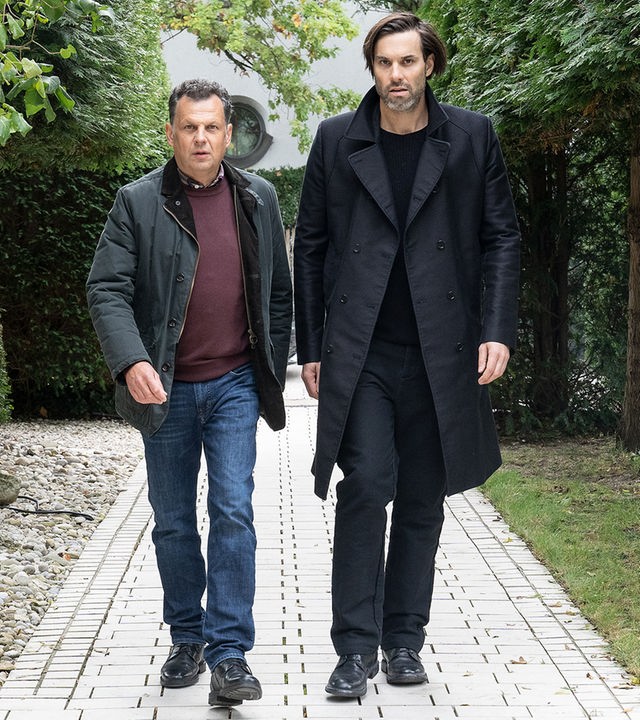 "Laim und die Toten ohne Hosen": Anton Simhandl (Gerhard Wittmann) und Lukas Laim (Max Simonischek) laufen nebeneinander einen Weg entlang.