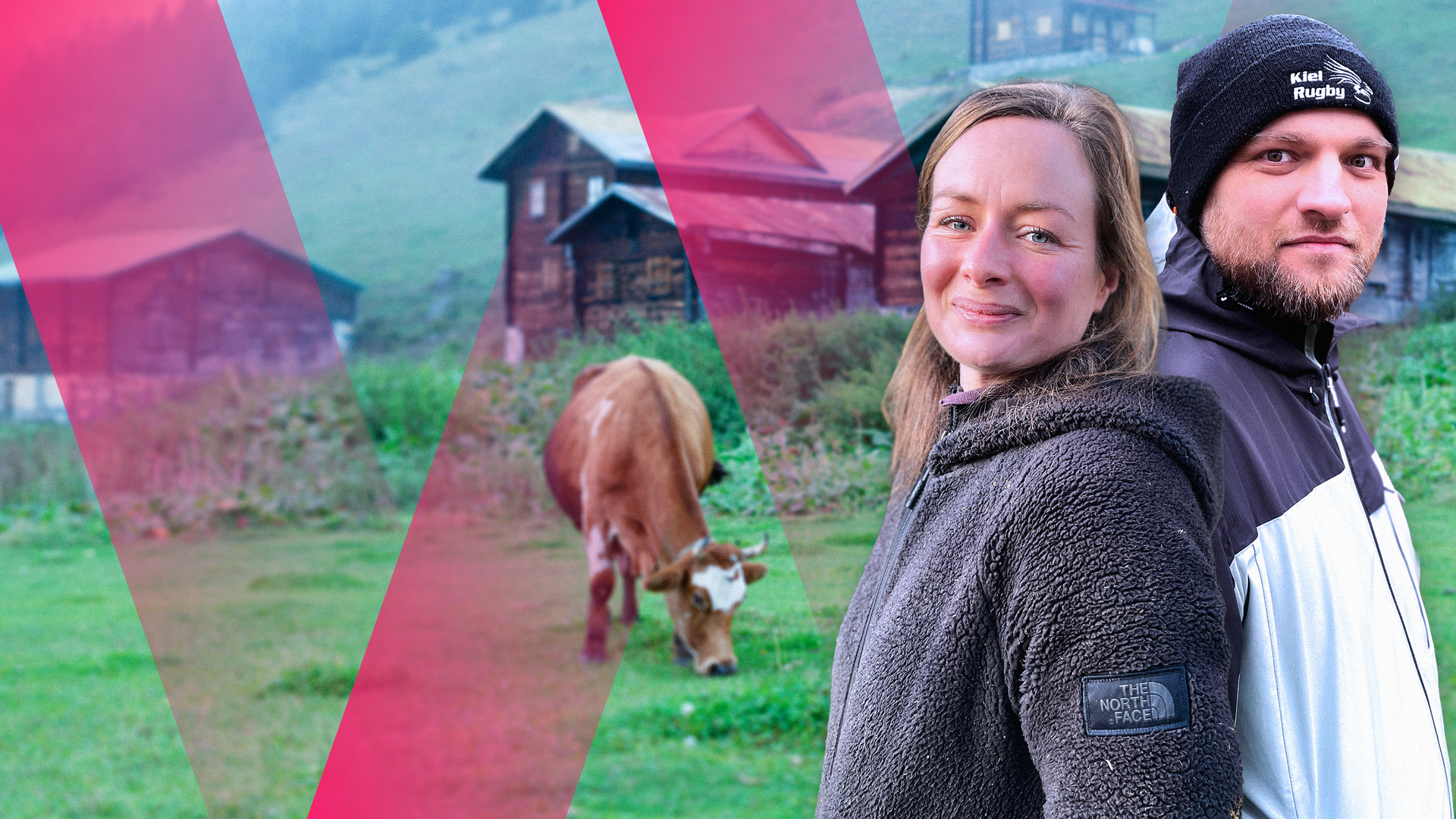 Eine junge Frau und ein junger Mann, im Hintergrund ein Almbauernhof und eine Kuh auf der Weide