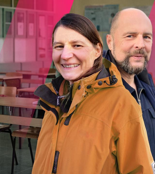 Eine junge Frau und ein junger Mann stehen in einem Klassenzimmer