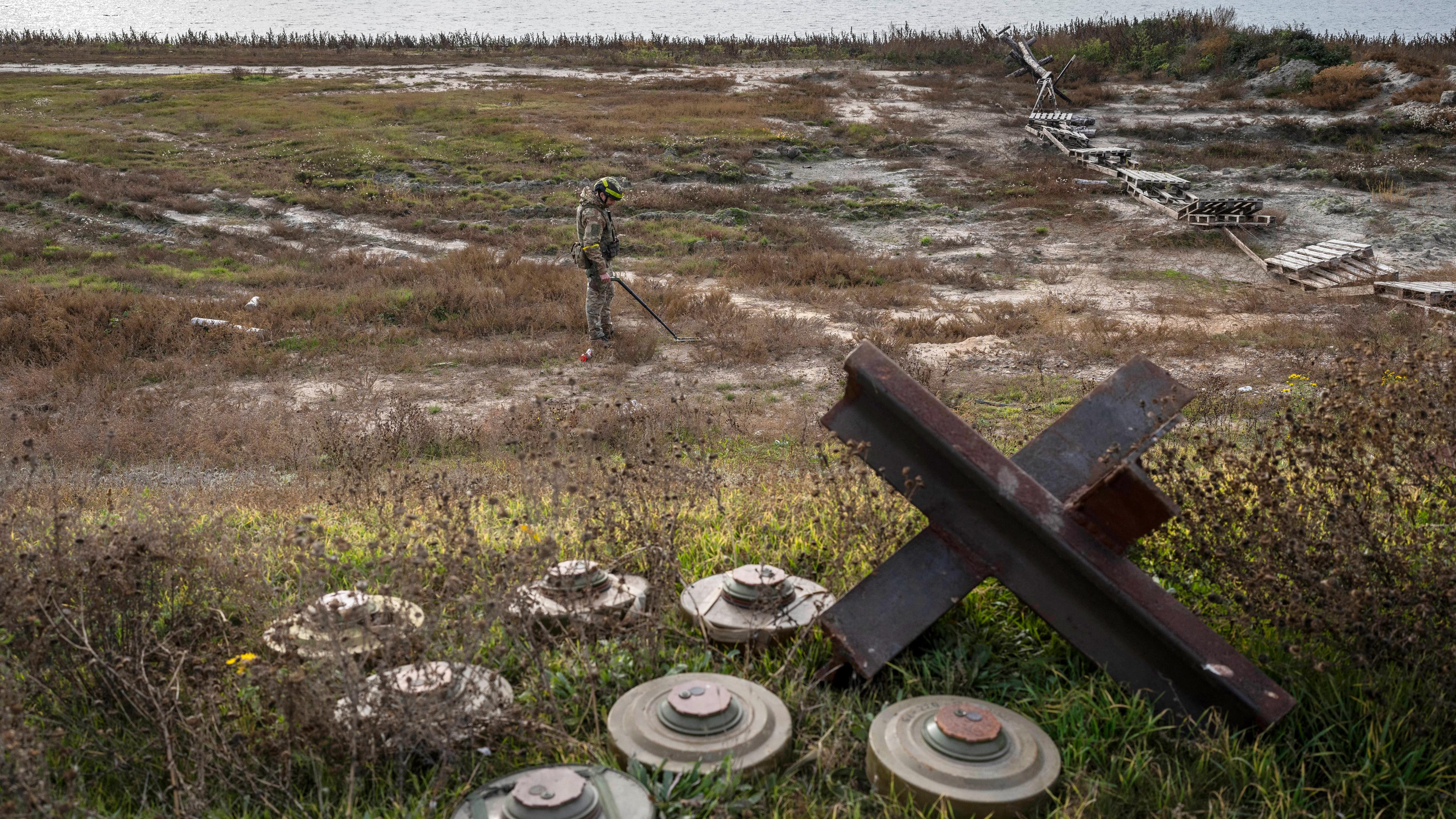 Ein ukrainischer Soldat sucht auf dem Feld eines kürzlich befreiten Dorfes am Rande von Cherson nach Minen, aufgenommen am 16.11.2022