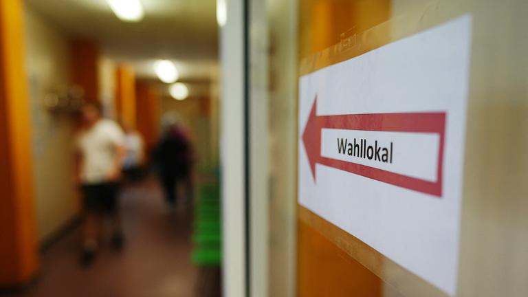 Ein Hinweisschild weist den Weg zu einem Wahllokal.
