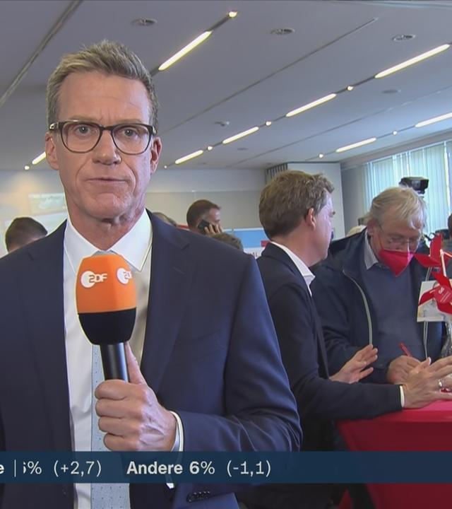 Links ZDFheute-Reporter Ralph Szepanski, im Hintergrund Parteimidglieder der SPD, unten Links ZDF logo