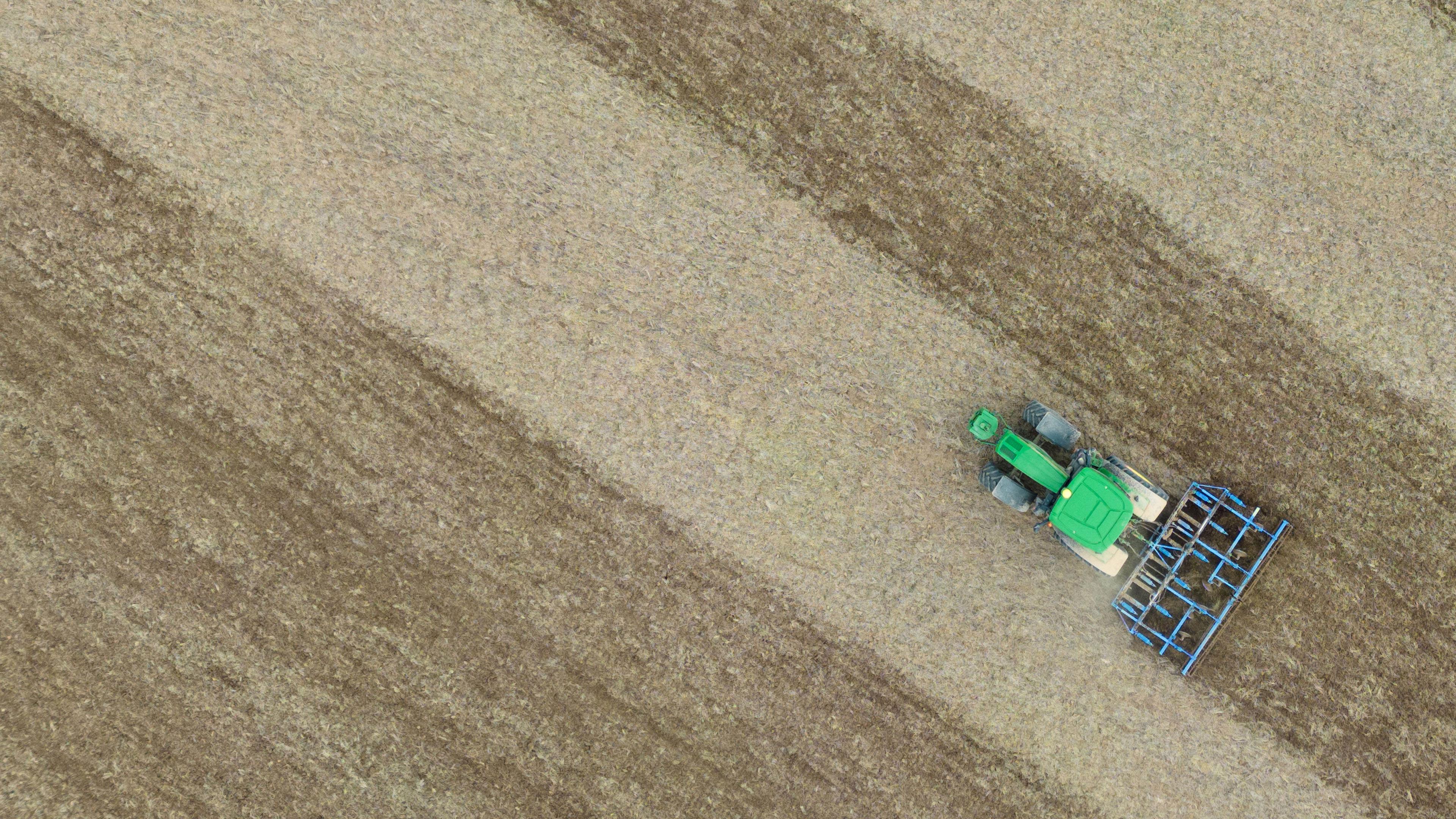 Eine Egge zieht dieser Landwirt hinter seinem Traktor über ein Feld in der hessischen Wetterau.
