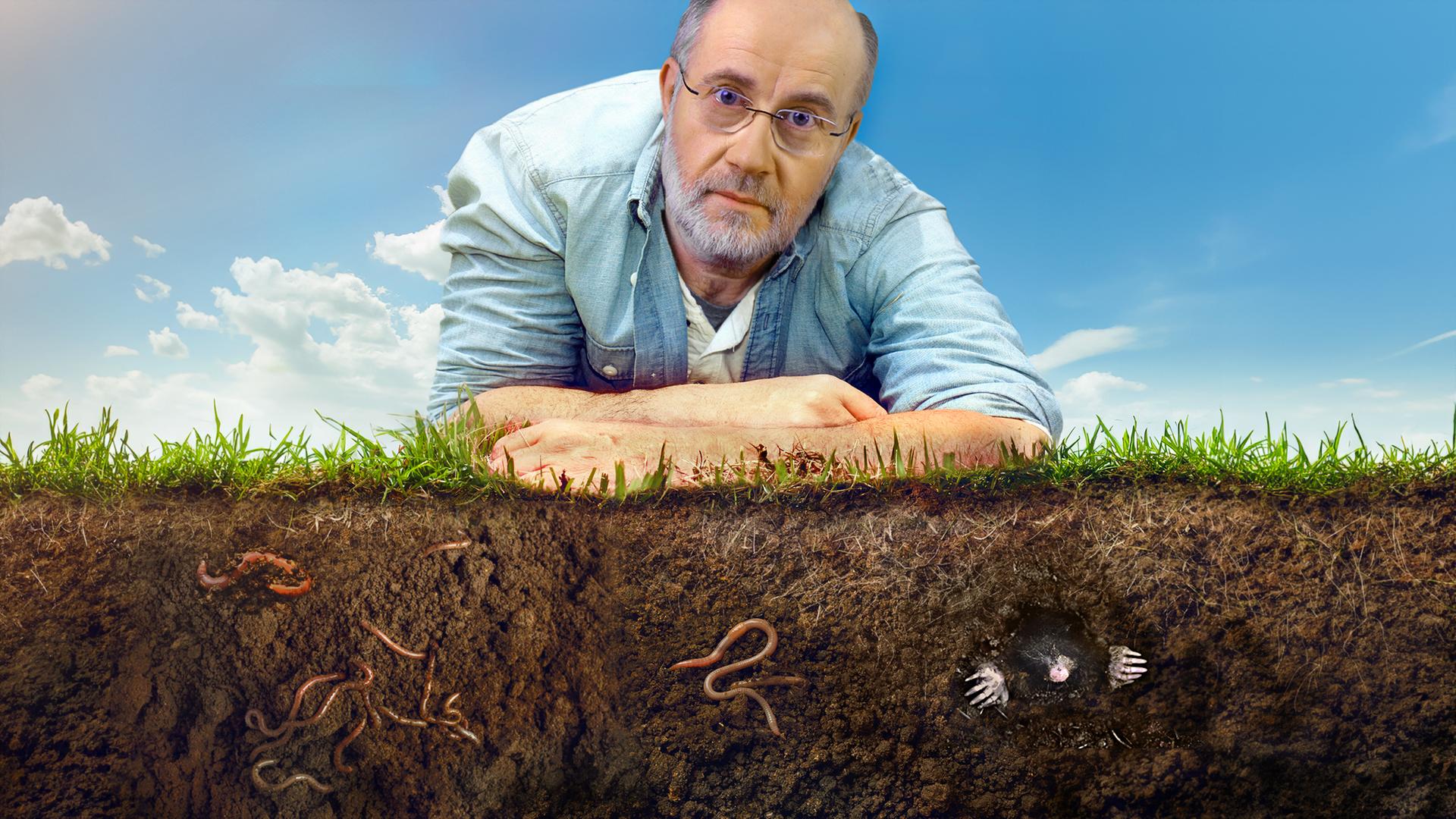 Harald Lesch liegt auf der Erde.