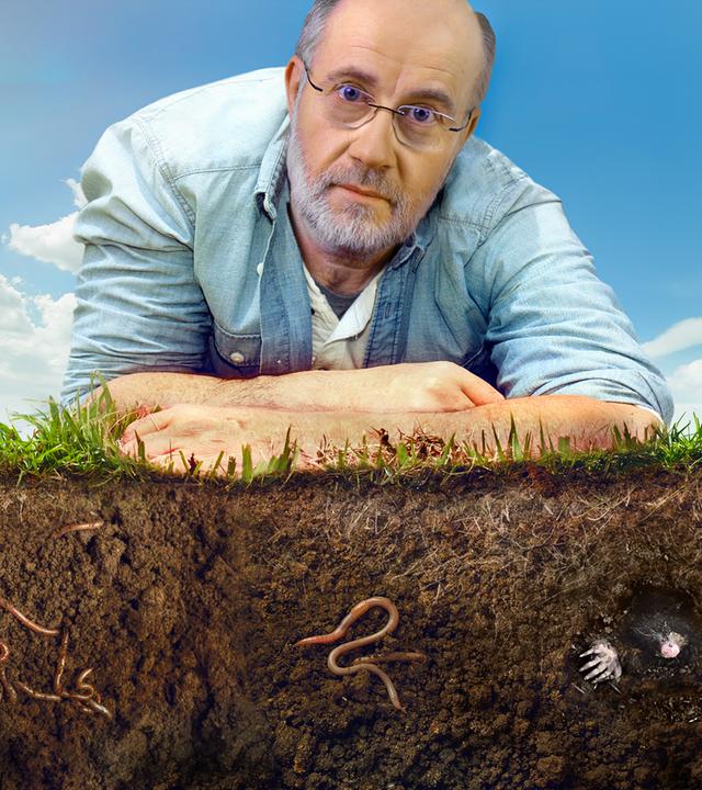 Harald Lesch liegt auf der Erde.