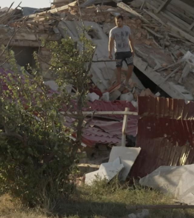 Bauer Vitaliy auf den Trümmern seines Hauses