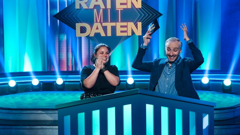 Moderator Jan Böhmermann in der ZDF Prime Time Sendung "Lass dich überwachen!" gemeinsam mit Kandidatin Samantha aus Bergisch Gladbach in der Rubrik Raten mit Daten. Jan Böhmermann jubelt und hat die Arme in der Luft.