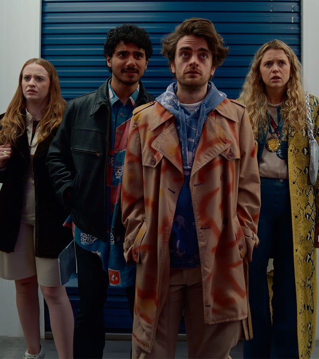 "Extraordinary - Lassen wir's krachen?": Die vier Freunde Jen (Máiréad Tyers), Kash (Bilal Hasna), Jizz (Luke Rollason) und Carry (Sofia Oxenham) stehen alle nebeneinander und schauen nach vorne. Jen wirkt irritiert, hält schwer an ihrer Hängetasche fest. Kash hat die Hände in der Jacke und Jizz schaut verzweifelt in den Lagerraum. Carry wirkt genervt.