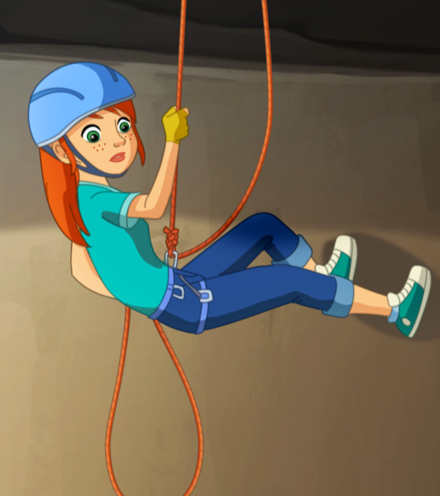 Zoé hängt in einer Felswand in den Seilen und blickt nach unten.