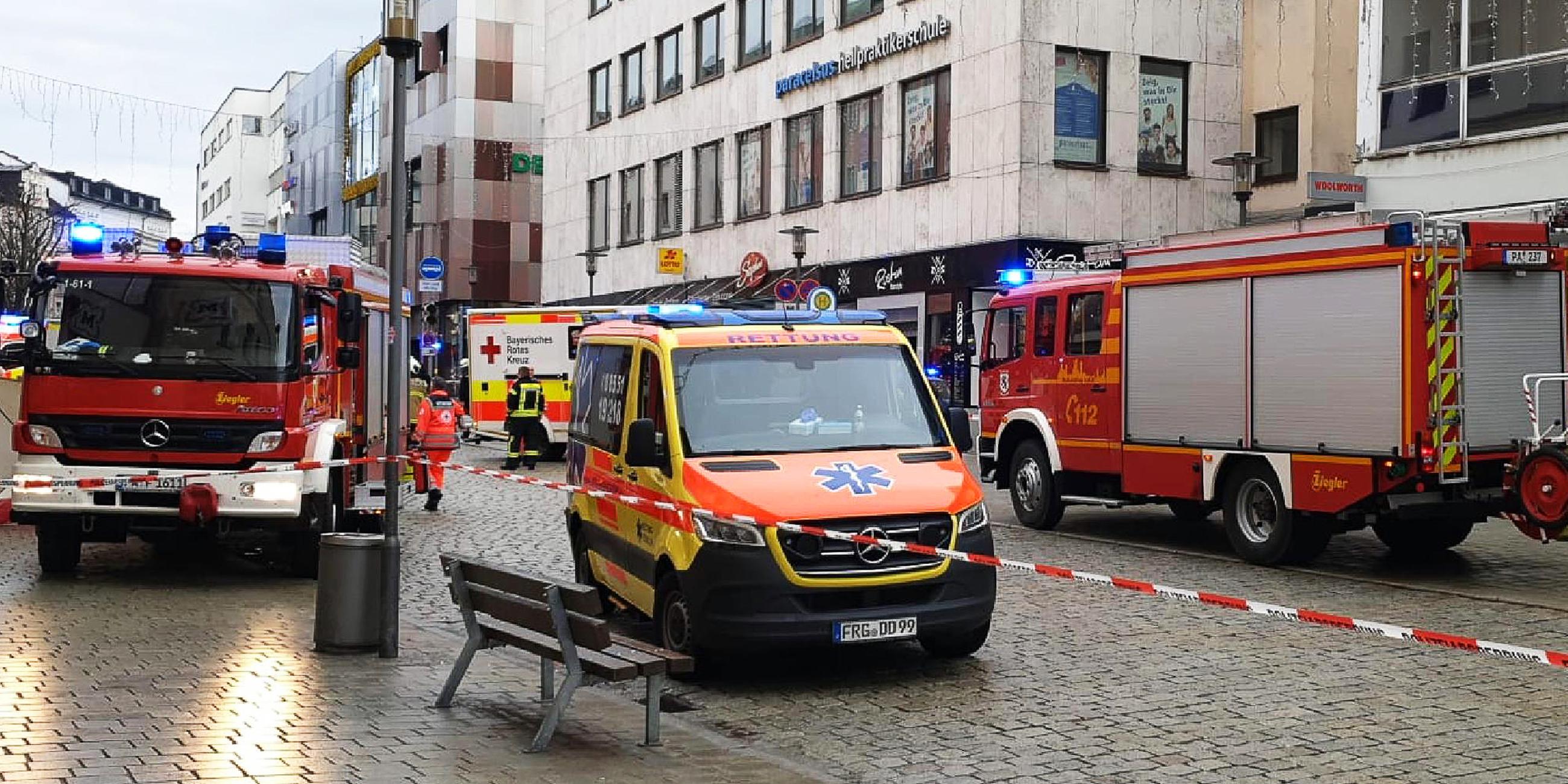 Einsatzkräfte von Feuerwehr und Rettungsdienst stehen in der Innenstadt in Passau am Einsatzort. 
