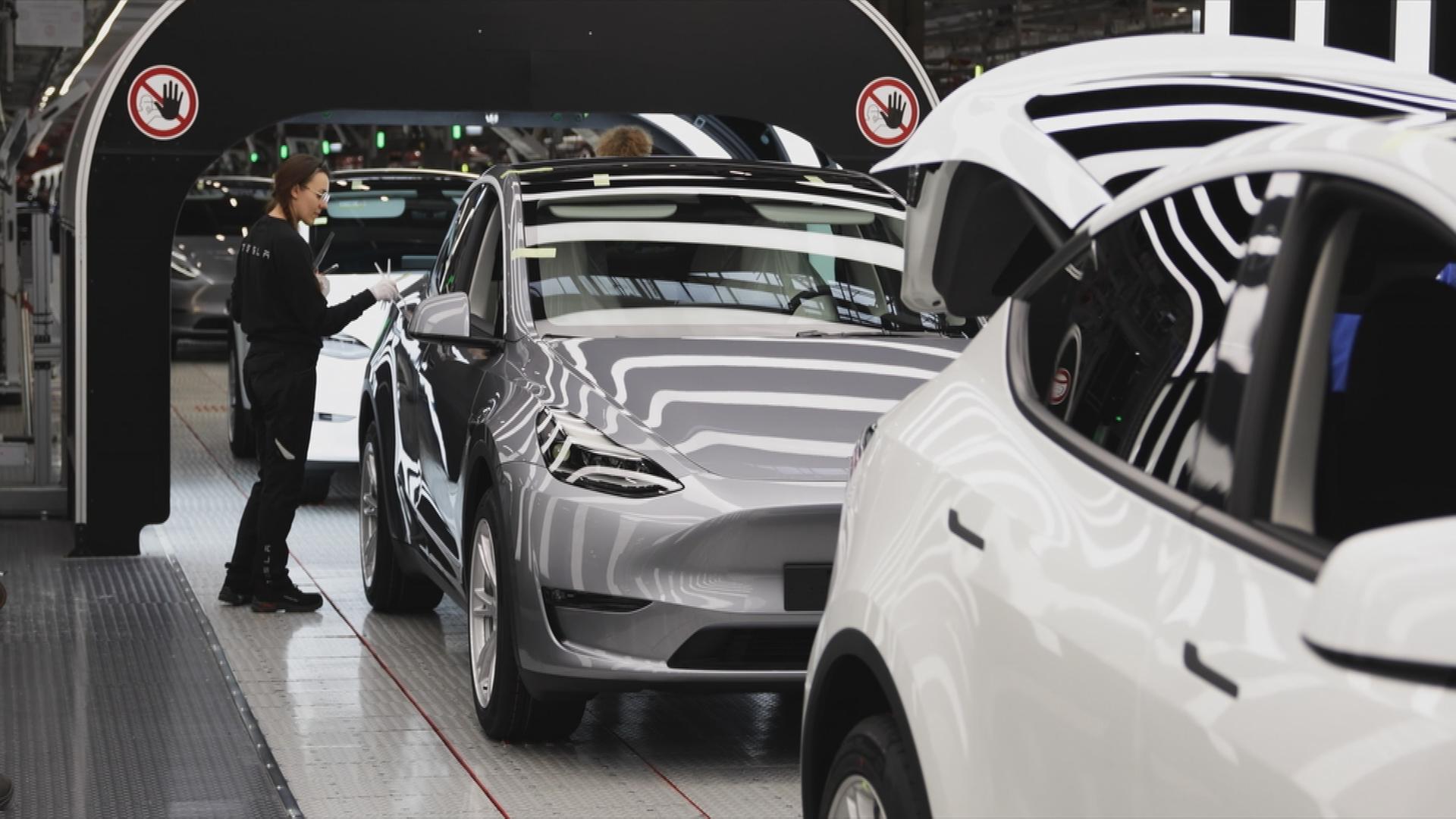 Auf dem Bild sind neue Autos auf einem Laufband innerhalb des Teslawerks in Deutschland zu sehen.