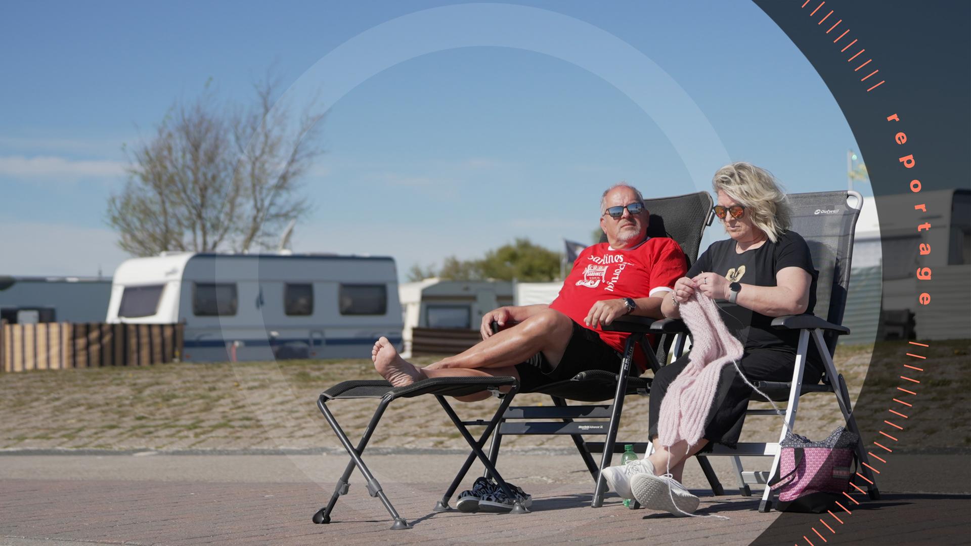 Kristina Schumann und ihr Mann Manfred sitzen auf Campingstühlen vor ihrem Wohnwagen und genießen die Sonnenstrahlen.