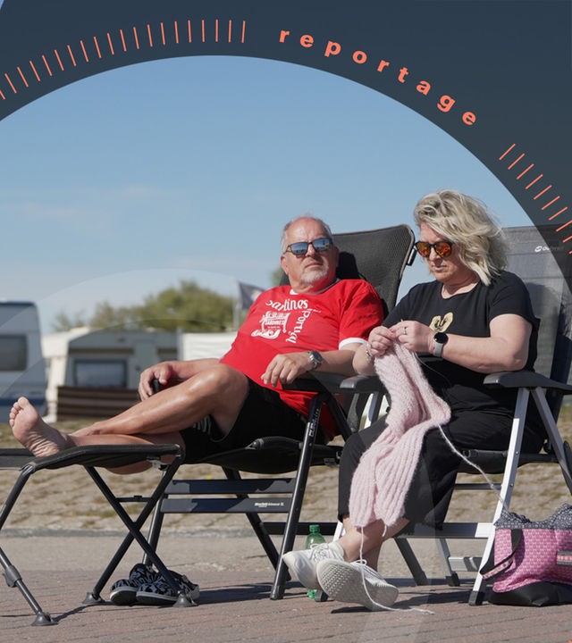 Kristina Schumann und ihr Mann Manfred sitzen auf Campingstühlen vor ihrem Wohnwagen und genießen die Sonnenstrahlen.