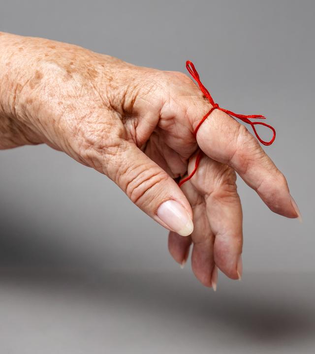 Ausgestreckter Finger mit einer Schleife zur Erinnerung daran. 