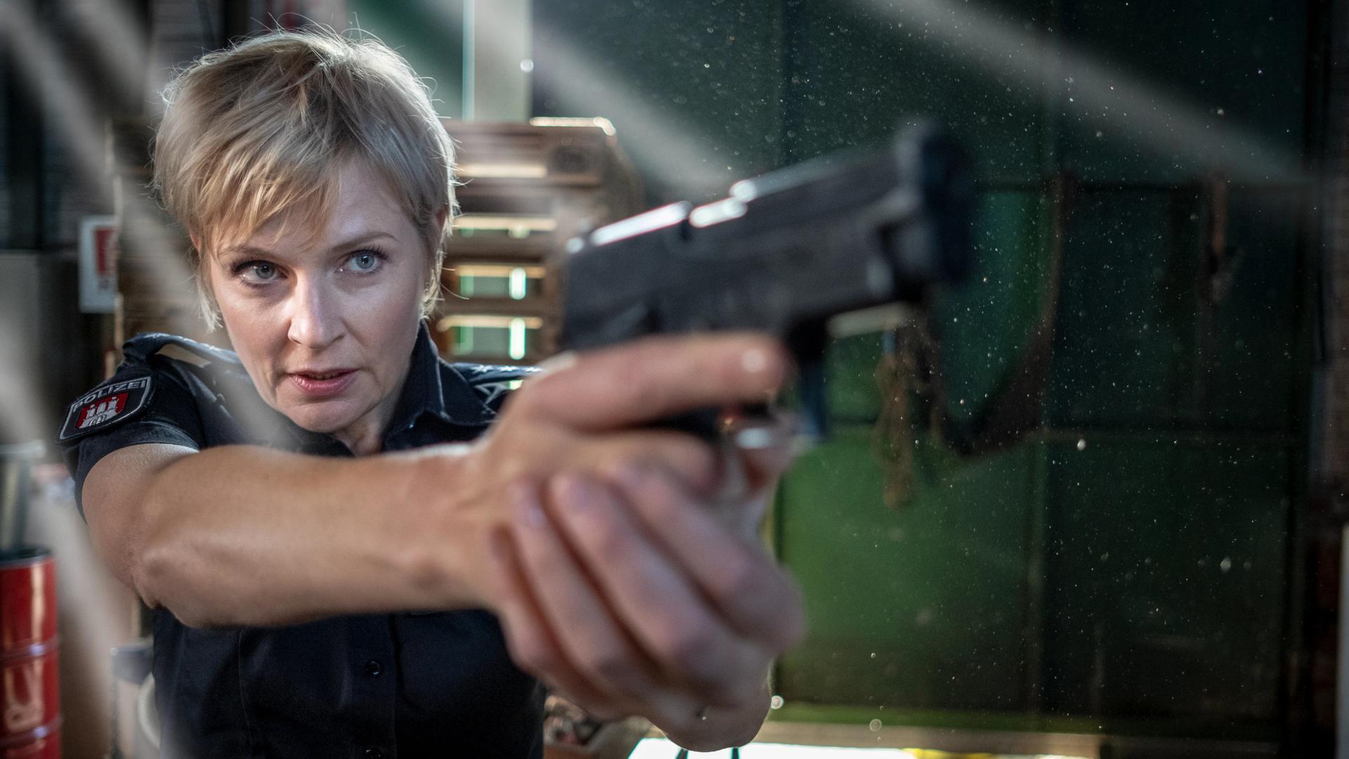 "Notruf Hafenkante - Lebensmüde": Nahaufnahme von Melanie Hansen (Sanna Englund), die mit ihrer Waffe auf etwas vor sich zielt.