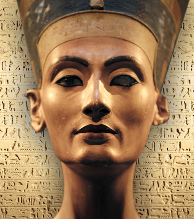 Montage: Die Büste der Nofretete steht vor Hieroglyphen.