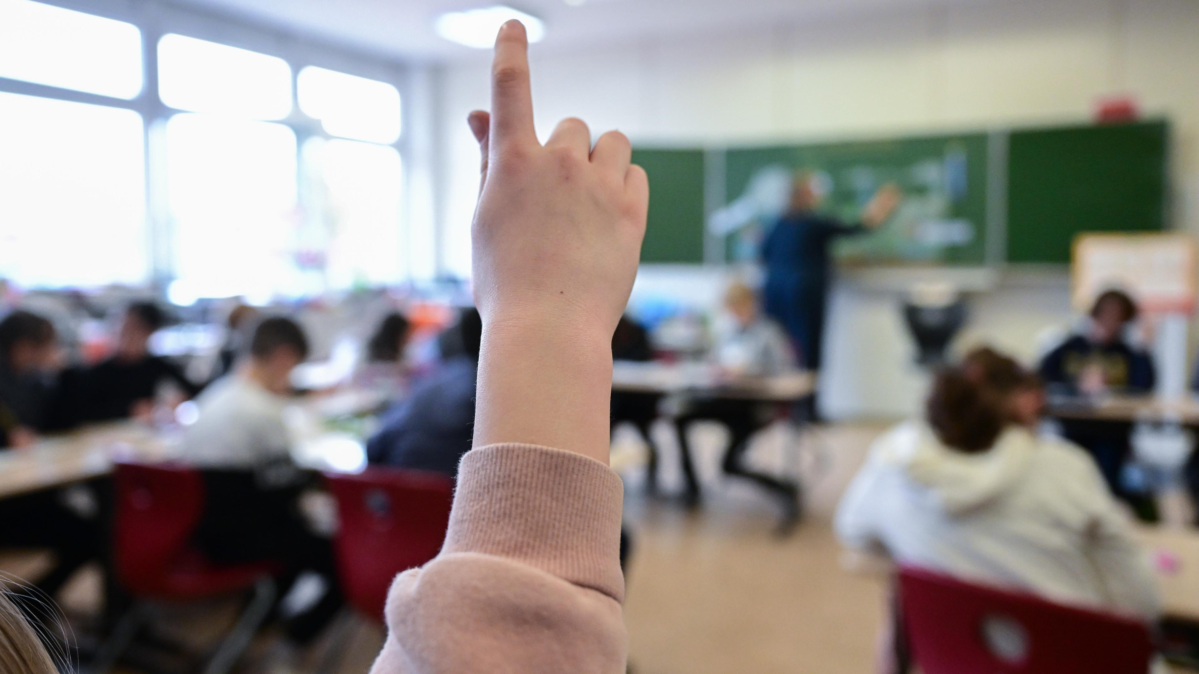 Schülerin hebt Hand im Klassenzimmer einer Schule; Stuttgart; 06.03.2023