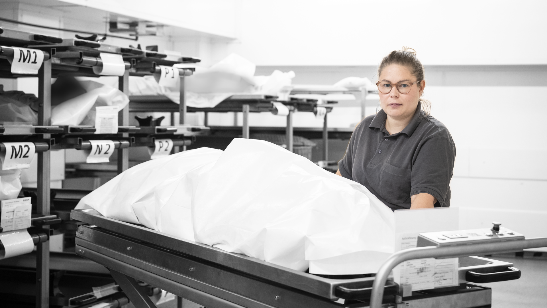Marleen steht vor einer Bridge, auf der ein Tuch über einer Leiche liegt.
