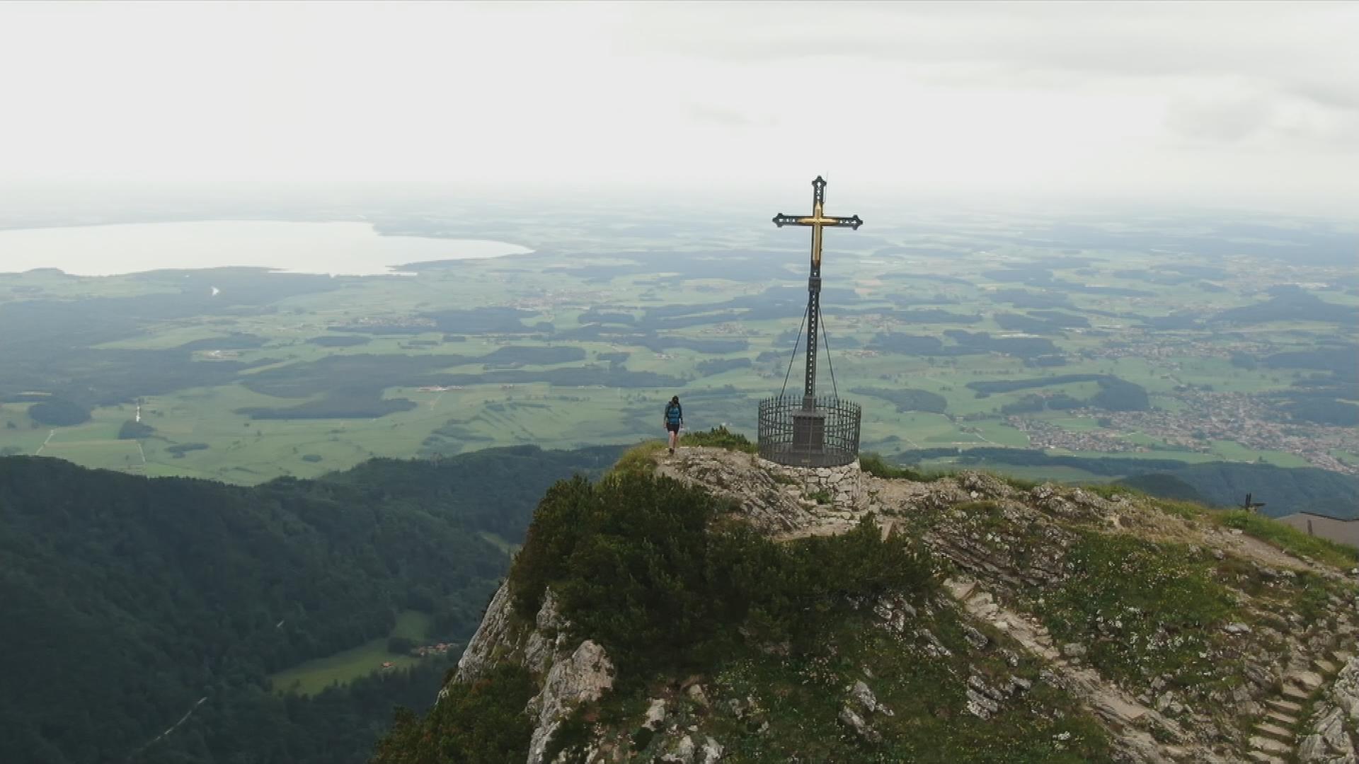 Eine Bergspitze auf der ein Kreuz steht