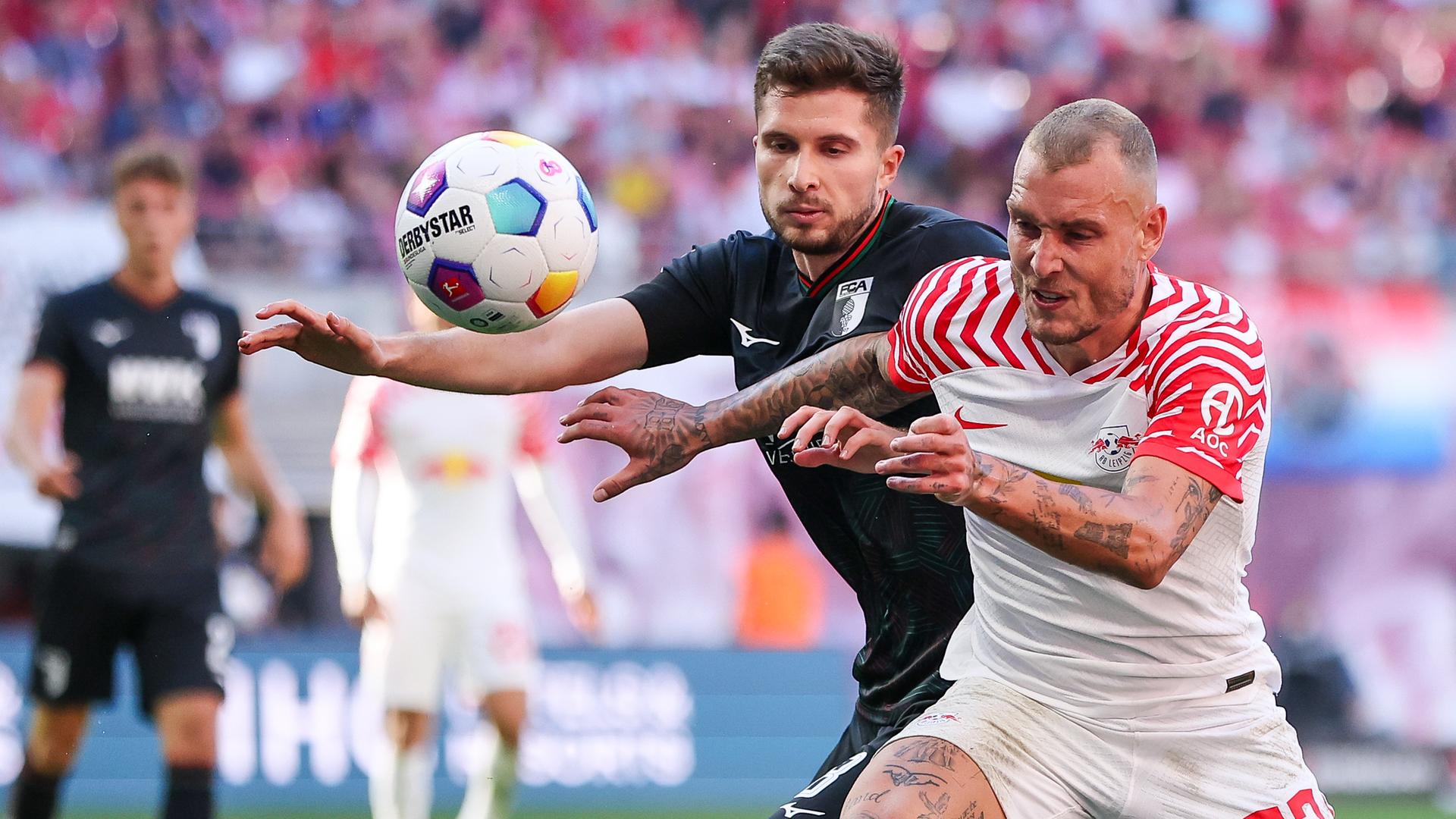 Leipzigs Spieler David Raum und Augsburgs Elvis Rexhbecaj im Duell am 16.09.2023.