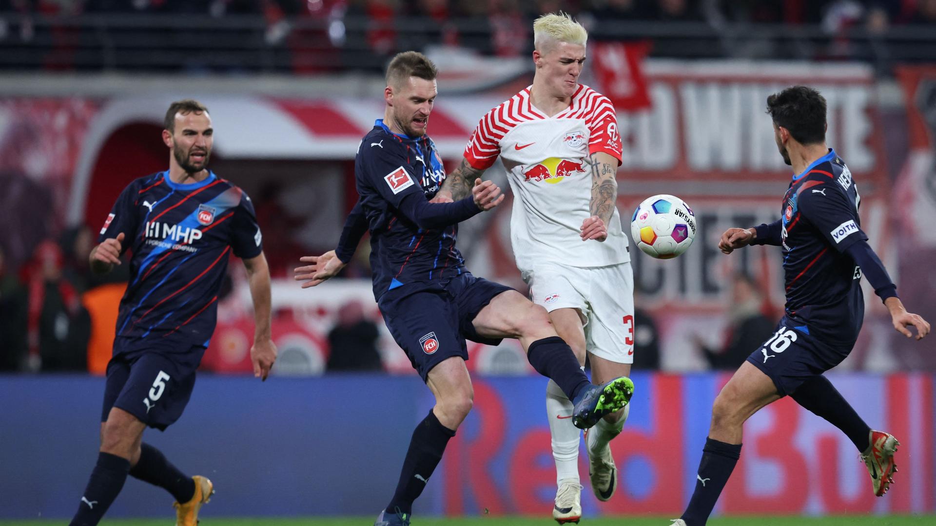 Heidenheims Kevin Sessa und Leipzigs Benjamin Sesko kämpfen am 02.12.2023 um den Ball.