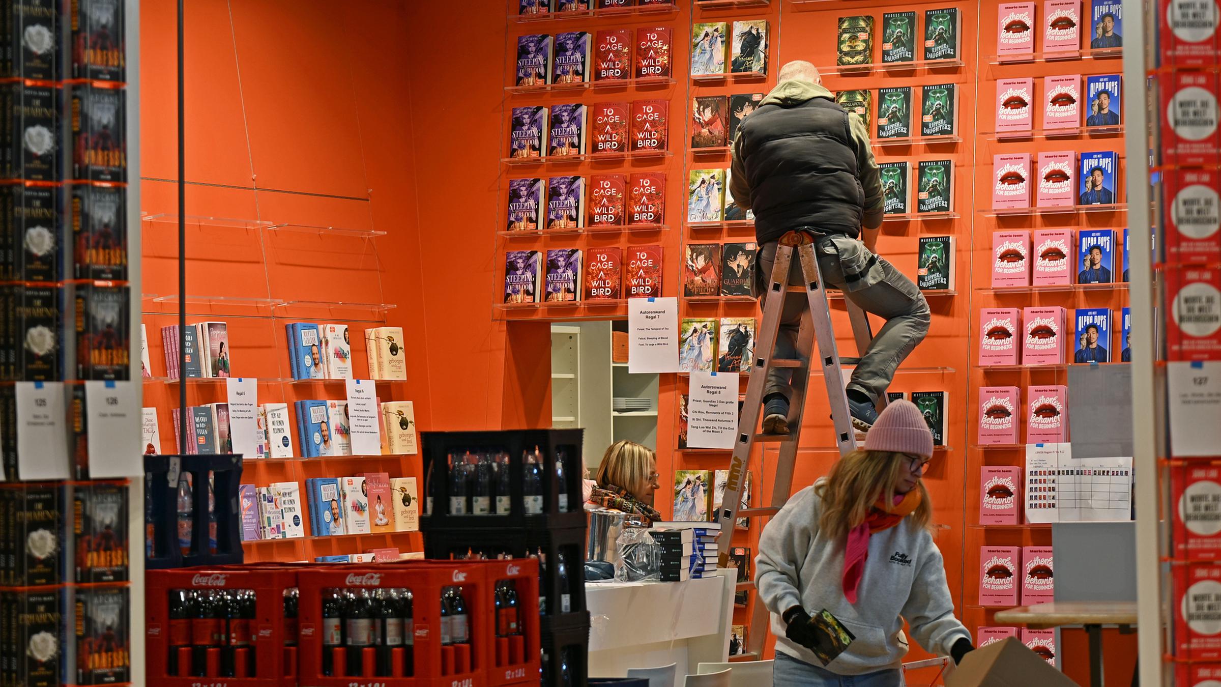Ein Mitarbeiter räumt ein Regal am Stand des Verlages Droemer Knaur auf der Leipziger Buchmesse ein.