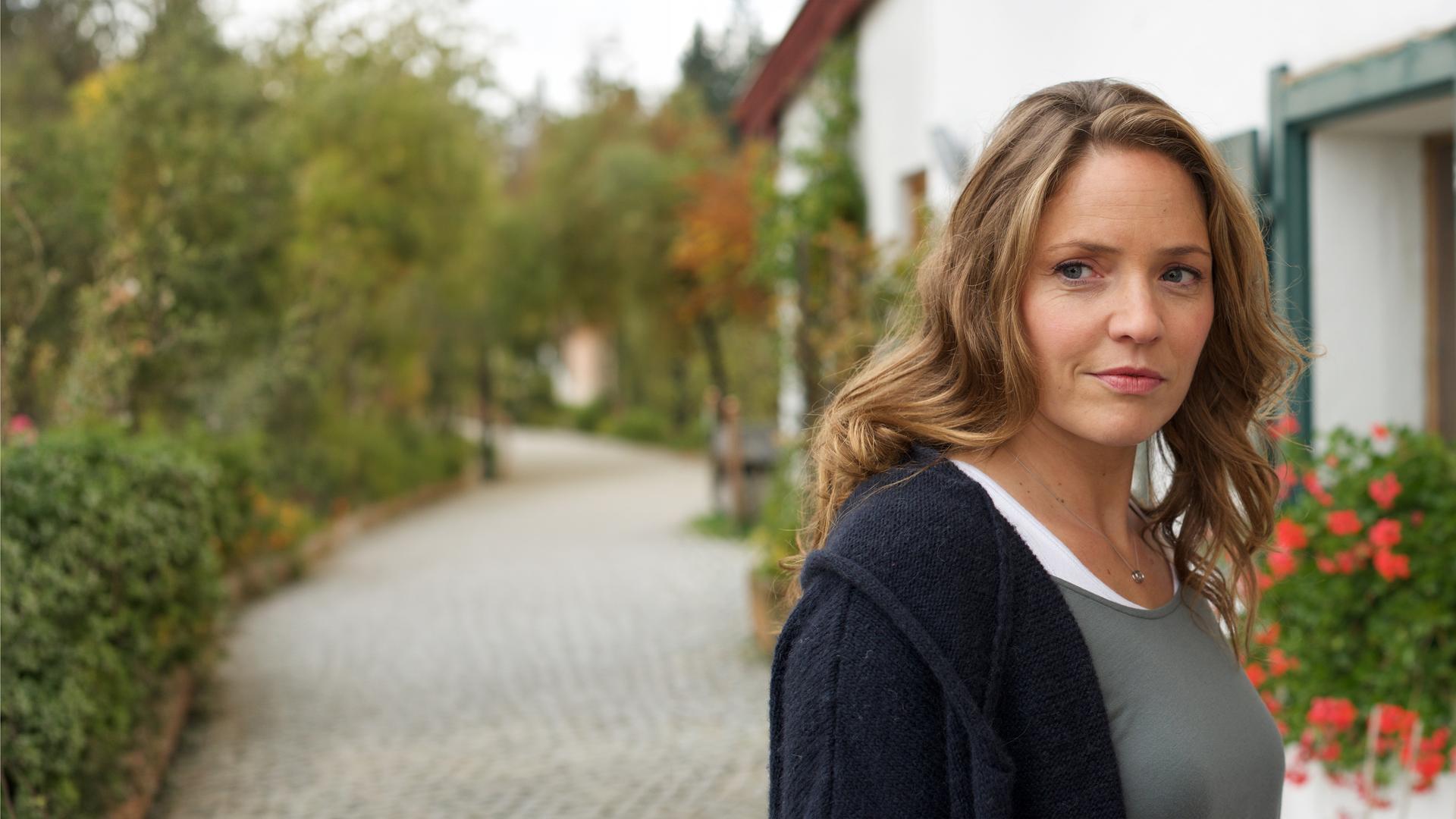 "Lena Lorenz - Ein Fall von Liebe": Lena Lorenz (Patricia Aulitzky) steht vor einem Gasthof; ihr Blick strahlt freudige Erwartung aus.