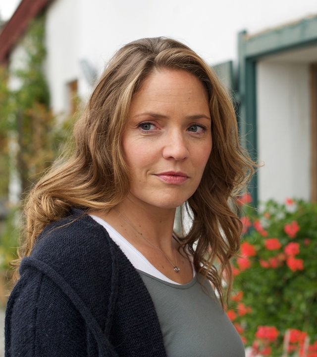 "Lena Lorenz - Ein Fall von Liebe": Lena Lorenz (Patricia Aulitzky) steht vor einem Gasthof; ihr Blick strahlt freudige Erwartung aus.